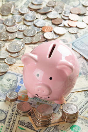 United States bank notes and coins with a piggy bankの写真素材