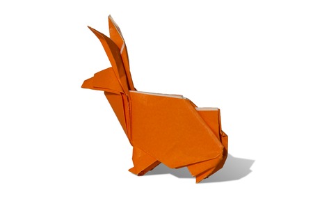 Origami rabbit made of colored paper. the rabbit is standing on a white surface and casts shadow.
It has long pointy ears.の写真素材