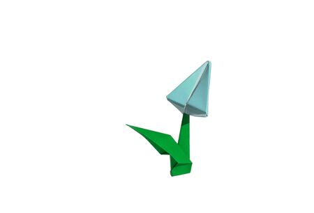 Origami tulip flower.
The tulip is isolated on white background and casts shadow on the surface. It has closed or open petals and a green stalk.の写真素材