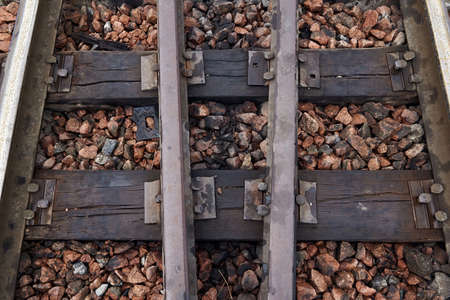 Close-up of old rusty steel rails, sleepers and gravel. Oiled sleepers near the railway station. Rails section on the railway. With sleepers on rubble.の写真素材