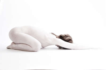 Naked young woman in yoga pose on her knees in high-keyの写真素材