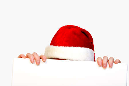 Beautifull girl in christmas bikini and with christmas hat is holding up a white sign for copy spaceの写真素材