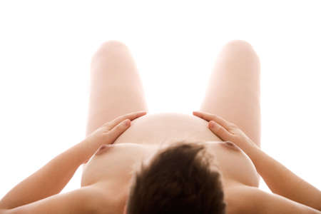 Studio portrait of a naked pregnant woman lying on her backの写真素材