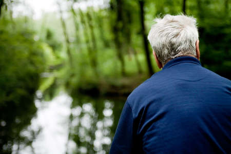 outside portrait of a man looking over waterの写真素材