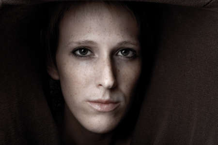 Studio portrait of a cute and beautifull girl in a turtle neck sweater looking mesmerizingの写真素材