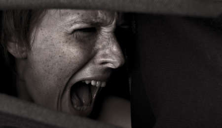 Studio portrait of a cute and beautifull girl in a turtle neck sweater screaming