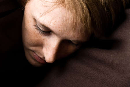 Studio portrait of a cute and beautifull girl hiding away in a turtle neck sweaterの写真素材