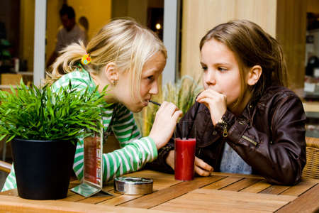 Two cute children having a drink toghetherの写真素材