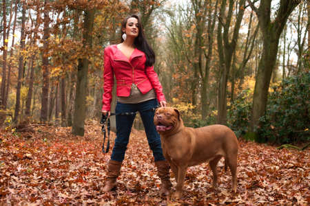 Young woman is having fun with her dog in the forestの写真素材