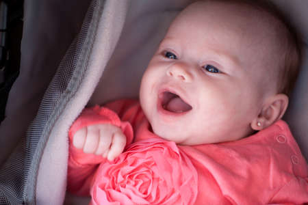 Happy baby is smiling in her pramの写真素材