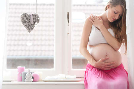 Young new mother is waiting for her childの写真素材