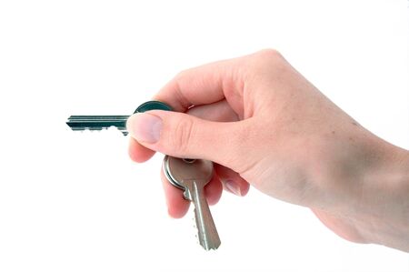 An isolated image of a hand holding keys ready to open a lock