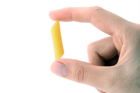An Isolated image of hand delicately holding one piece of pastaの写真素材