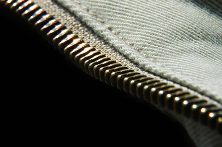 A macro shot with Black background showing a zipper
