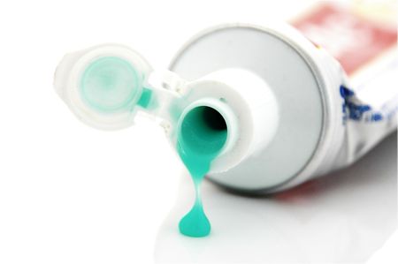 An Isolated to white close up photo of a toothpaste tube drippingの写真素材