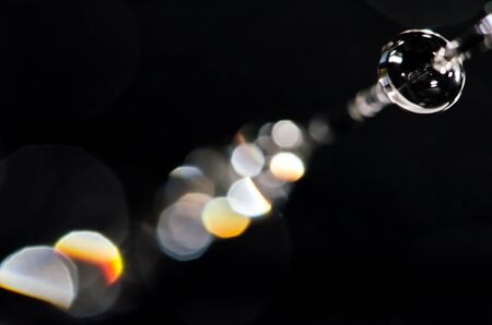 An abstract macro photo of a water drop on a black background.