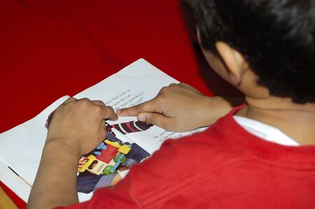 A Kid trying to read a storyの写真素材