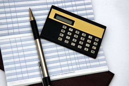 Check Book, transaction ledger, pen and calculator against a light backgroundの写真素材