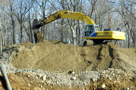 A crane digging up the soil to build houses