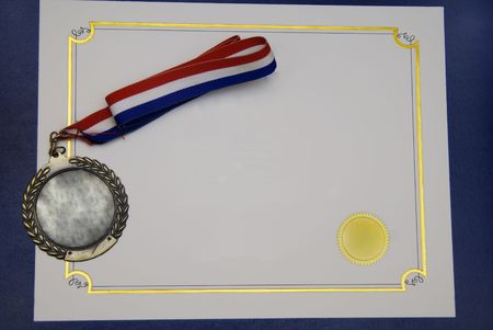 A Certificate and a gold medal on a blue pad - concept of graduationの写真素材