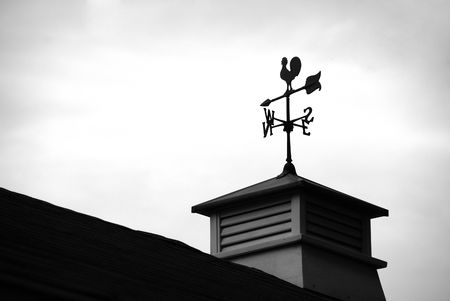 Siloutte of a wind direction at the top of a roofの写真素材