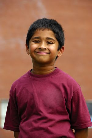 A happy Indian school kid smiling in front of the classroomの写真素材