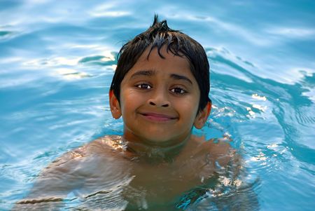 An young indian boy having fun swimming in the pool\r\rの写真素材