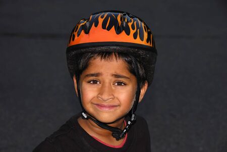 An handsome Indian kid wearing an helmet for safetyの写真素材