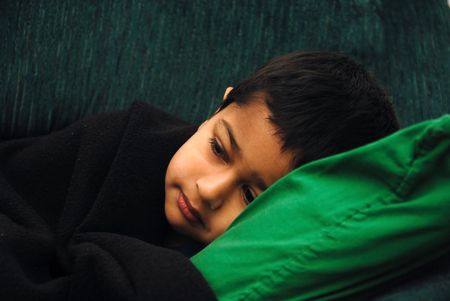 An young kid lying in bed feeling very sickの写真素材