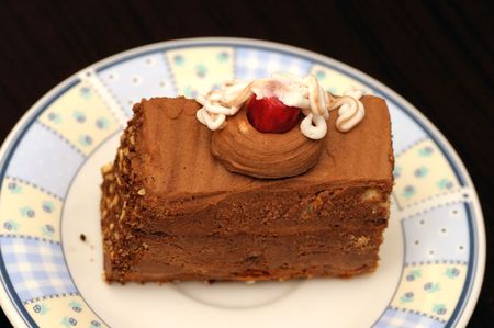 A slice of chocolate cake on a plate ready to eatの写真素材