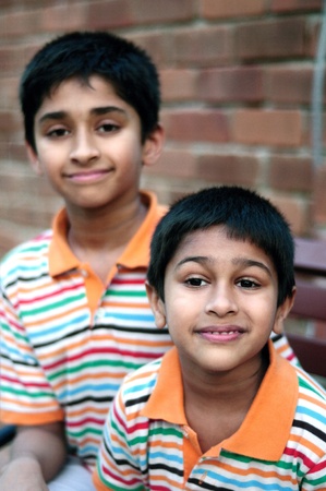 Two Indian brothers sitting happily at a local park