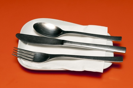 Spoon, fork and tissue set on a resturant tableの写真素材
