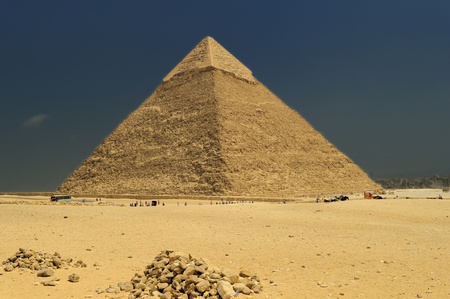 A row of camels transport tourists in front of all of the Giza Pyramids in Cairo, Egyptのeditorial素材