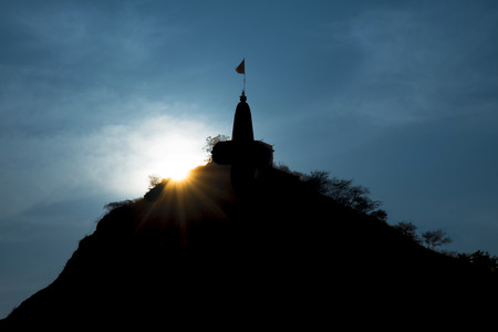 Sun setting over a hill temple in Rajasthan Indiaの写真素材