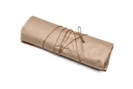 parcel package wrapped with brown kraft paper tied rope isolated on whiteの写真素材