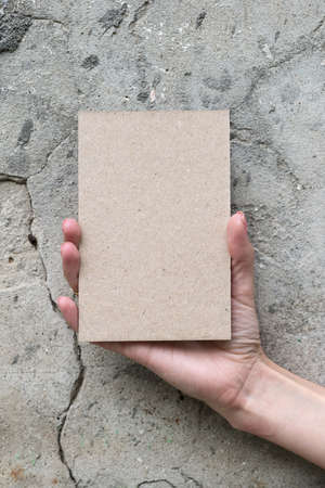 Greeting card in woman hand on wall backgroundの写真素材