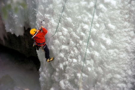 An Ice Climber going up a frozen waterfall.の写真素材