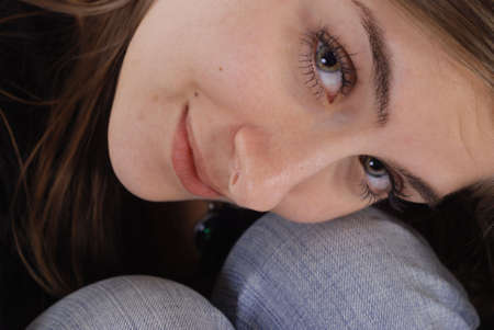 Beauty shot of a brunette curled up to her kneesの写真素材