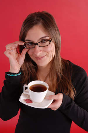 Glasses girl holding tea on red backgroundの写真素材
