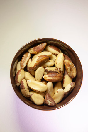 Brazil nuts in a dark ceramic bowl. Top view.の写真素材