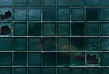 Damaged glass block window at an infrastructure facility. Dark background. The concept of stealth.の写真素材