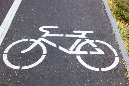 White bike lane marking on an asphalt road. Road markings for bicycle. Close-up.