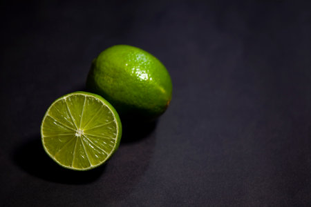 Limes against dark background, top view with copy spaceの写真素材