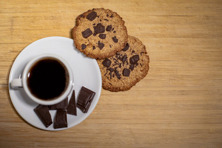 Homemade oatmeal cookies and a cup of coffee on a wooden table, top view.の写真素材