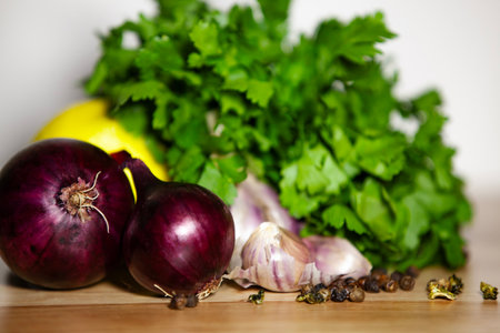 Close-up of fresh parsley with garlic, red onions and spices - rustic kitchen preparation.の写真素材