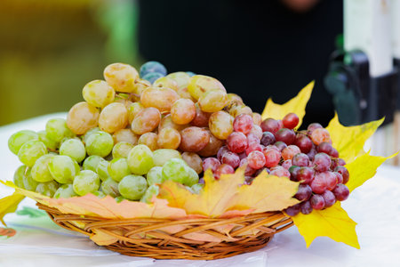 Grapes in basket on market table. Fresh grapes displayed in a basket at local market, natural fruit...