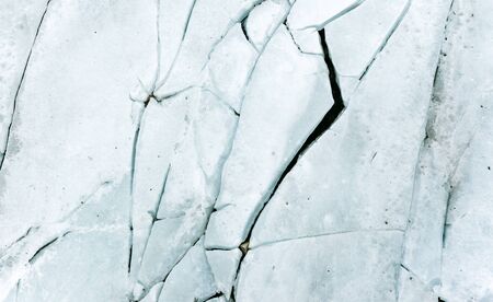 ice background texture with a long crack and rockの写真素材