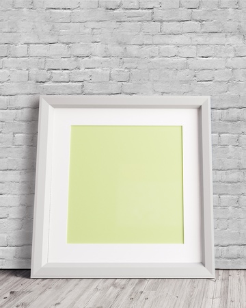 3d blank white picture frame with brick wall and wooden floor  3D illustrationの写真素材