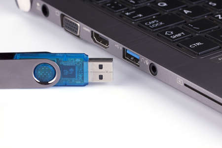Blue flash disk and laptop with USB slot - detail USB connector and USB port