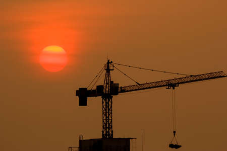 the crane is working while the sun is fallingの写真素材